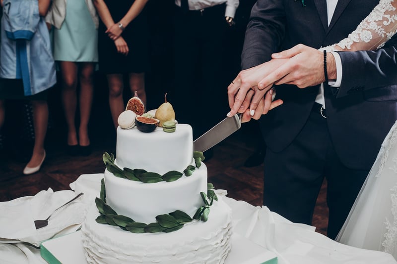 Happy Wedding Couple Cutting Together Wedding Cake. Rustic Cake